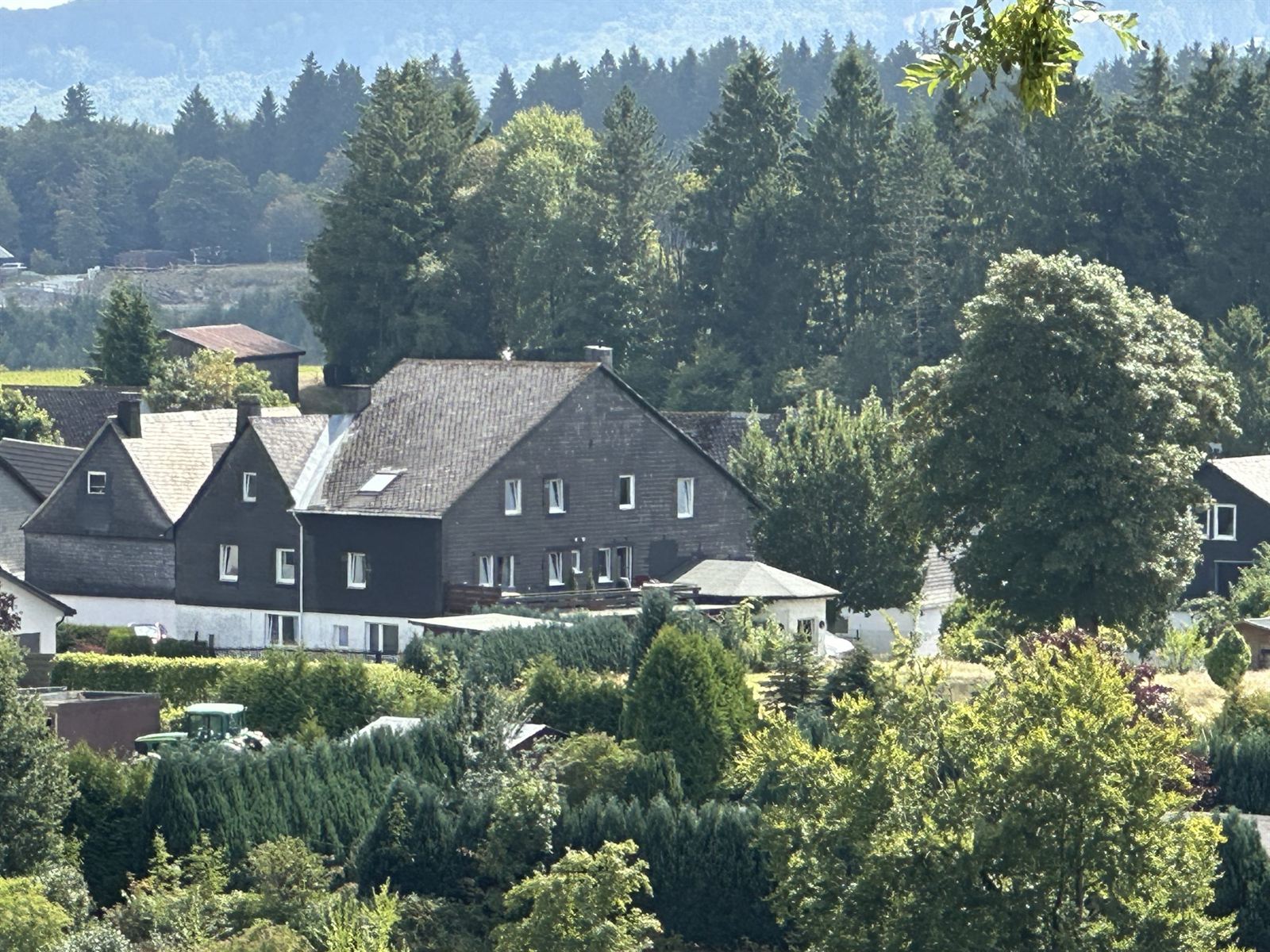 Uitzicht over het dorp en de groene weiden en heuvels in de zomer